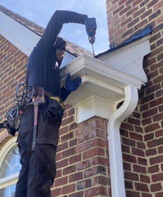 A person replacing gutters in Smithfield, VA and Southside, VA